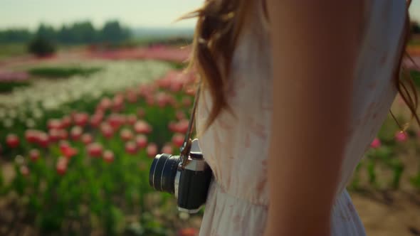Silhouette of Unknown Woman Enjoying Spring Sun Light in Blooming Flower Garden alt
