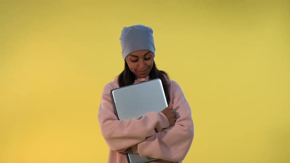 Portrait of African Girl in Cap Hugging Her Computer Laptop alt