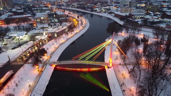 Illuminated bridge on winter river in Kharkiv city