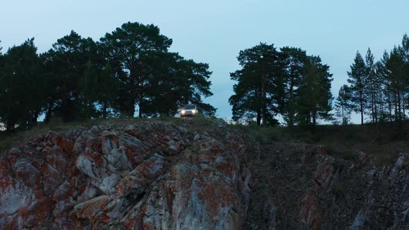 Aerial View of a Car on the Edge of a Cliff alt