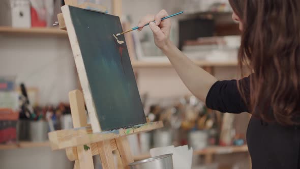 Woman Artist Painting in Studio alt