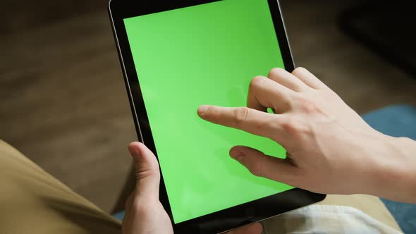 A Mockup of a Man Holds a Tablet Computer with Chroma Key Screen in His Hands alt