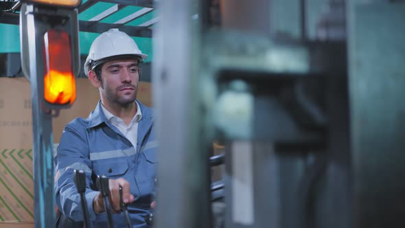 caucasian male engineer control fork lift truck loading product pallet with concentrate in warehouse alt