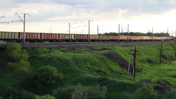 Freight Train Carriages Passing On A Railroad Track At Sunset