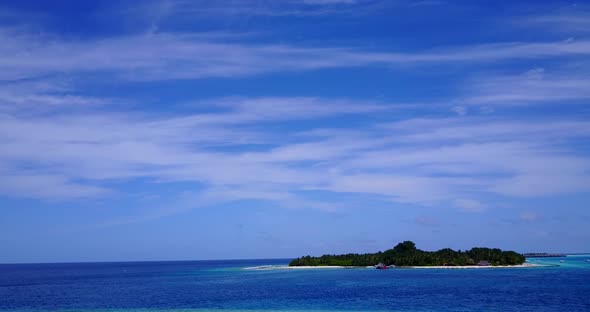 Daytime overhead tourism shot of a white sandy paradise beach and aqua blue ocean background alt