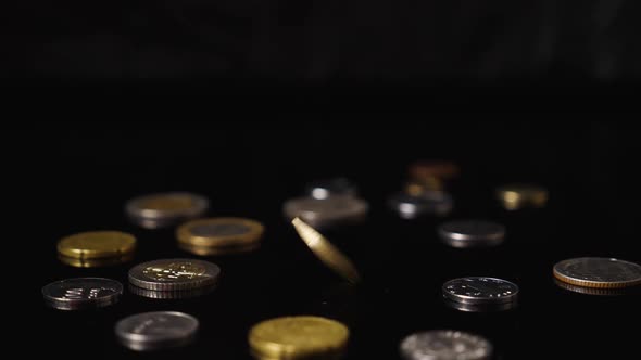 Coin Face Value of One Euro Rotates on a Black Mirrored Background alt