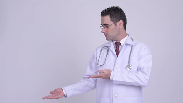 Handsome Man Doctor Showing Something Against White Background alt