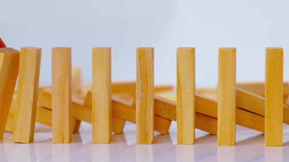 Domino Effect Row of Wooden Domino Falling Down on White Background alt