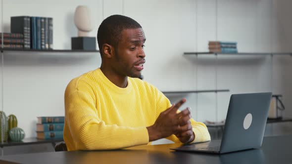 Young male online conversation greeting colleagues and smiles talking about success alt