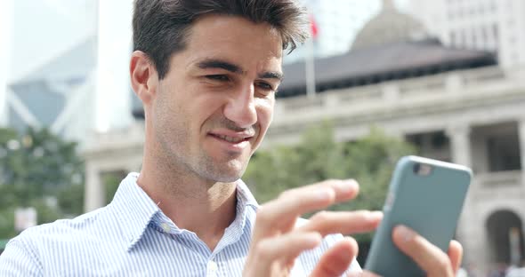 Businessman use of cellphone in Hong Kong city alt