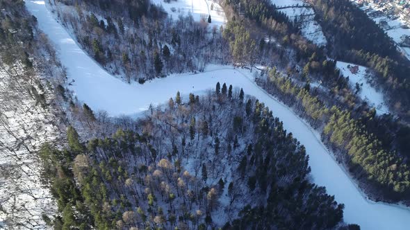Ski resort and ski slope in mountains during winter season, aerial view