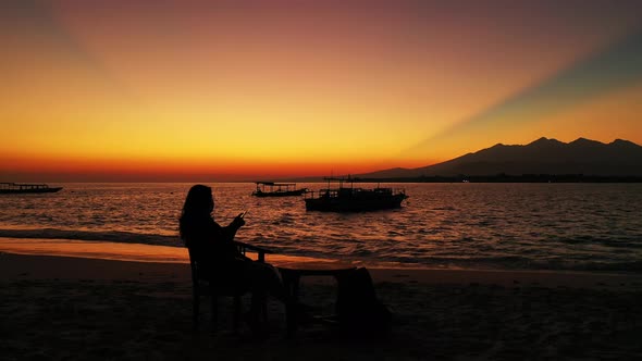 Pretty smiling girl relaxing in the sun on the beach on summer white sandy and blue 4K background alt