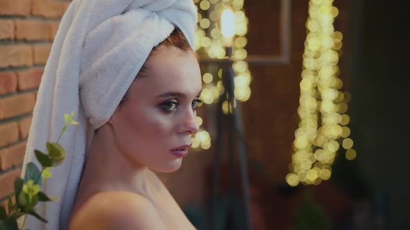 Portrait of Naked Woman Touches Her Neck and Looks at Camera alt