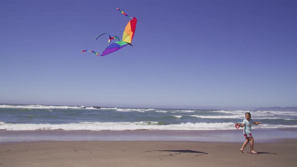 Young girl flying kite at beach