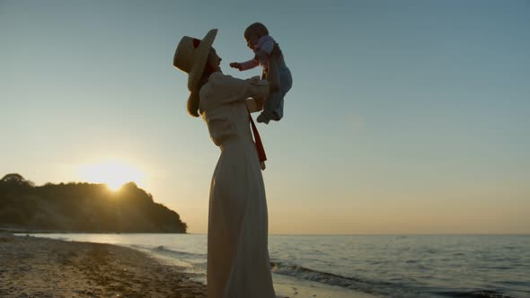 Young Woman with Child on the Background of the Sea Coast