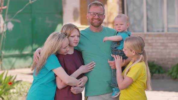 Happy family outdoors in the yard smiling and posing for the camera. alt