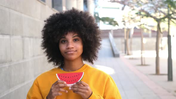 one happy and beauty cheerful woman holding a small watermelon covering her mouth