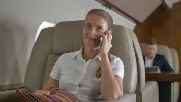 Sweet Female Speaking About Luxury Journey Inside of Private Jet alt