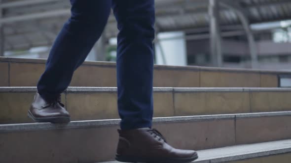 Close up of the legs Asian businessman walking in the street.