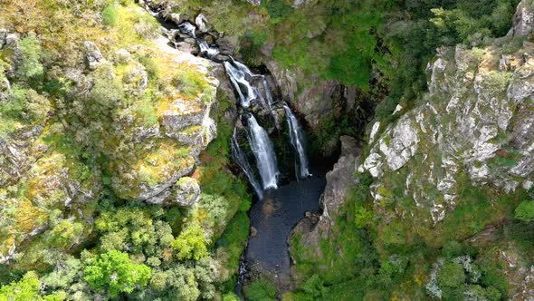 Aerial High Angle View Of Fervenza do Toxa Waterfalls Cascading Down Rockface. Pedestal Up, Tilt dow alt