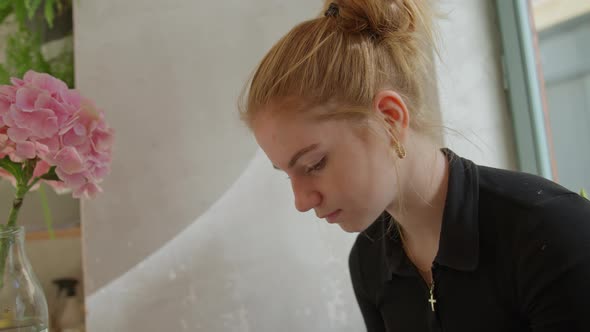 Young Woman Choosing From Menu In Cafe In Prague alt