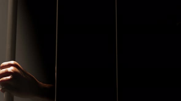 Loopable view at prisoner's hands behind bars. Sentenced men. Prison. 4k HD alt