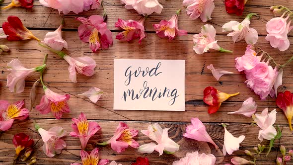 GOOD MORNING card near flowers on a wooden table top view alt