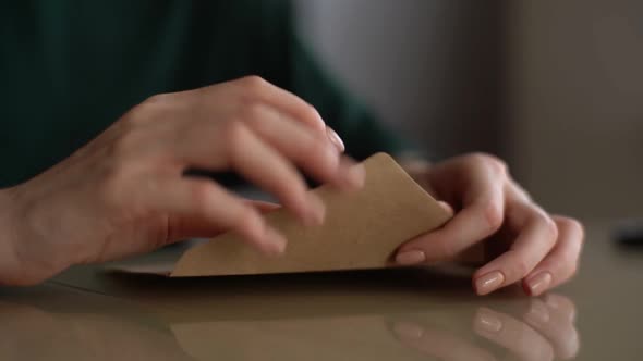 Attractive Young Woman Opening Envelope with Letter Reading It and Begins to Feel Happy at Home alt