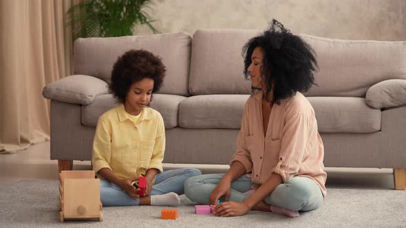 African American Woman and Litle Girl Played with Wooden Toy Car and Build Tower From Construction alt