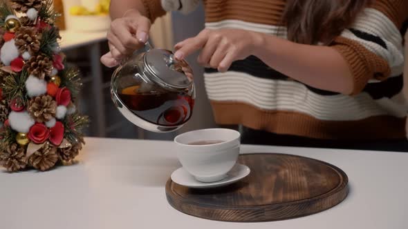 Close Up of Woman Pouring Tea From Kettle at Home alt