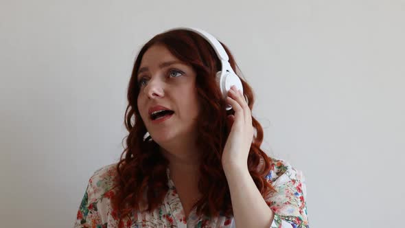 Cheerful Caucasian Woman Relaxing Listening to Music with Headphones Enjoying Sitting at Home