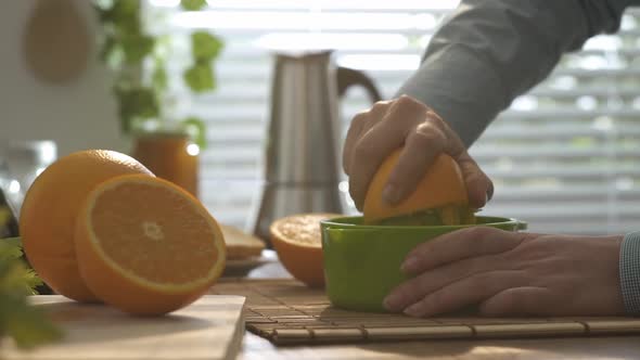 Woman preparing an healthy orange juice for breakfast