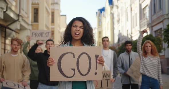 Public Demonstration at City Street with Mixed Race Woman in Front of Multiracial Protesting People alt