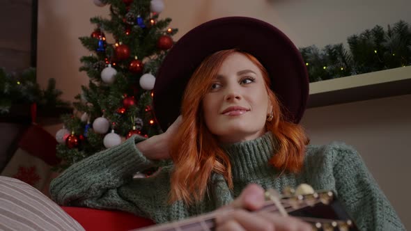 A wife listening to her husband playing the guitar alt