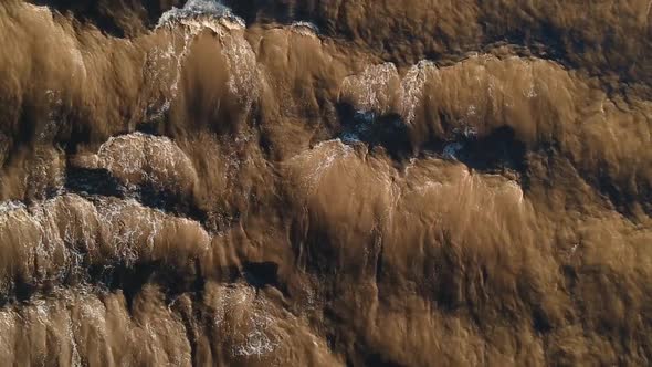 A fast flowing muddy river creating waves and patterns from the fast flowing current alt