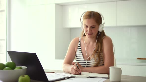 Woman in Headphones Writes with Pen During Video Lecture Spbd alt