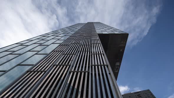 Clouds Passing Over Glass Skyscraper alt