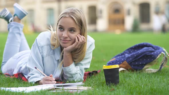 Student Girl Lying on The Grass and Studying