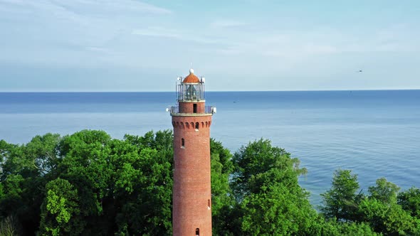 Lighthouse and birds on sunrise by Baltic Sea, aerial view alt