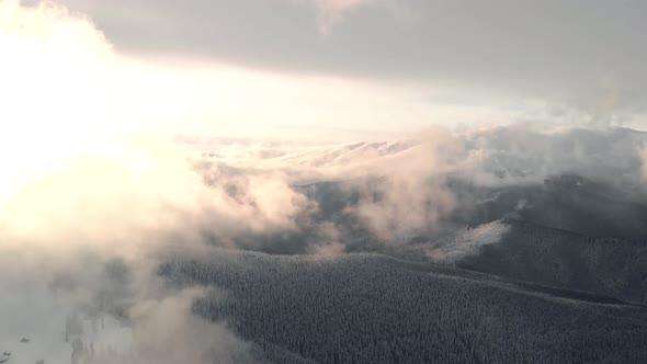 Aerial Flying Above Mountain Valley and Winter Forest at Sunrise alt