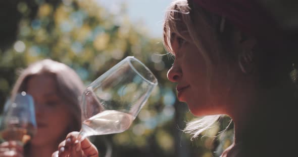 Attractive blonde young woman smelling white wine alt
