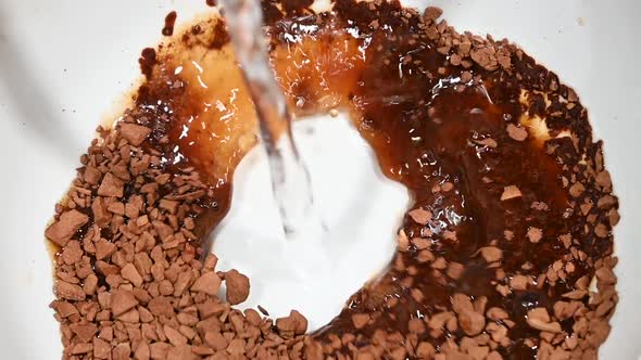 Pouring hot water in cup with freeze-dried soluble coffee granules, high angle view alt
