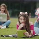 Two Female Sitting on the Grass and Using a Laptop and Tablet Device Computer - VideoHive Item for Sale