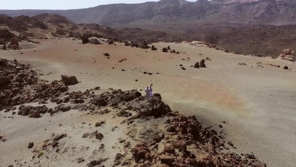 A Couple Stands on a Rock in the Crater of the Teide Volcano a Lunar Landscape on the Island of