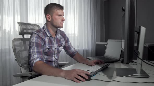 Handsome IT Office Worker Using Two Computers Working on a Project alt