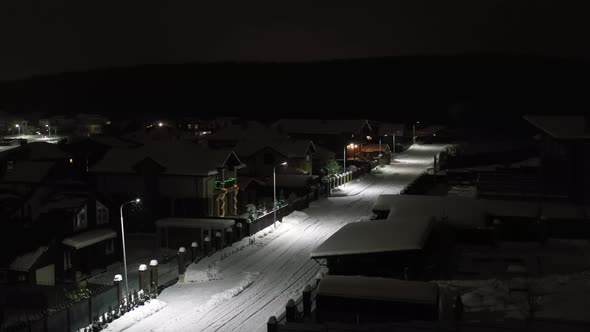 The Night Street of a Modern Village is Illuminated in Winter