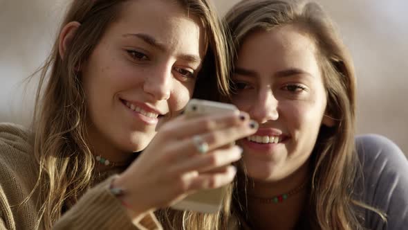 Teenage girls swiping on smartphone they are looking at alt