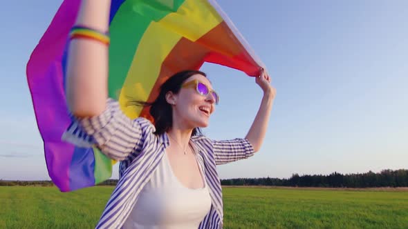 Young Attractive Woman Runs Across Field with LGBT Flag Slow Mo Close Up alt