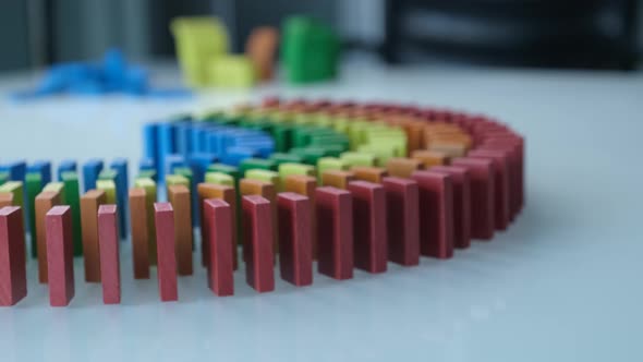 Line up of Dominoes in Rainbow Falling Colors with LGBT Colors of a Hand alt