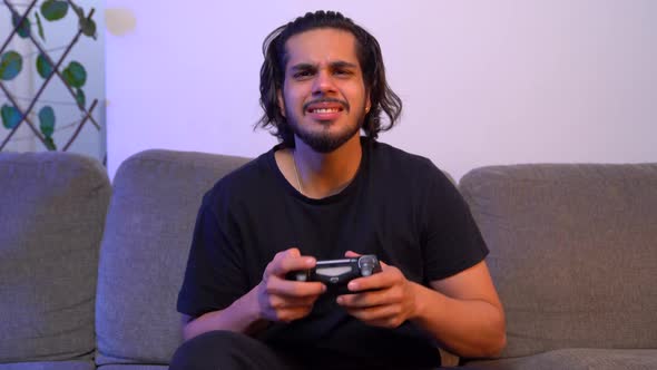 Angry Indian gamer playing video games late at night alt